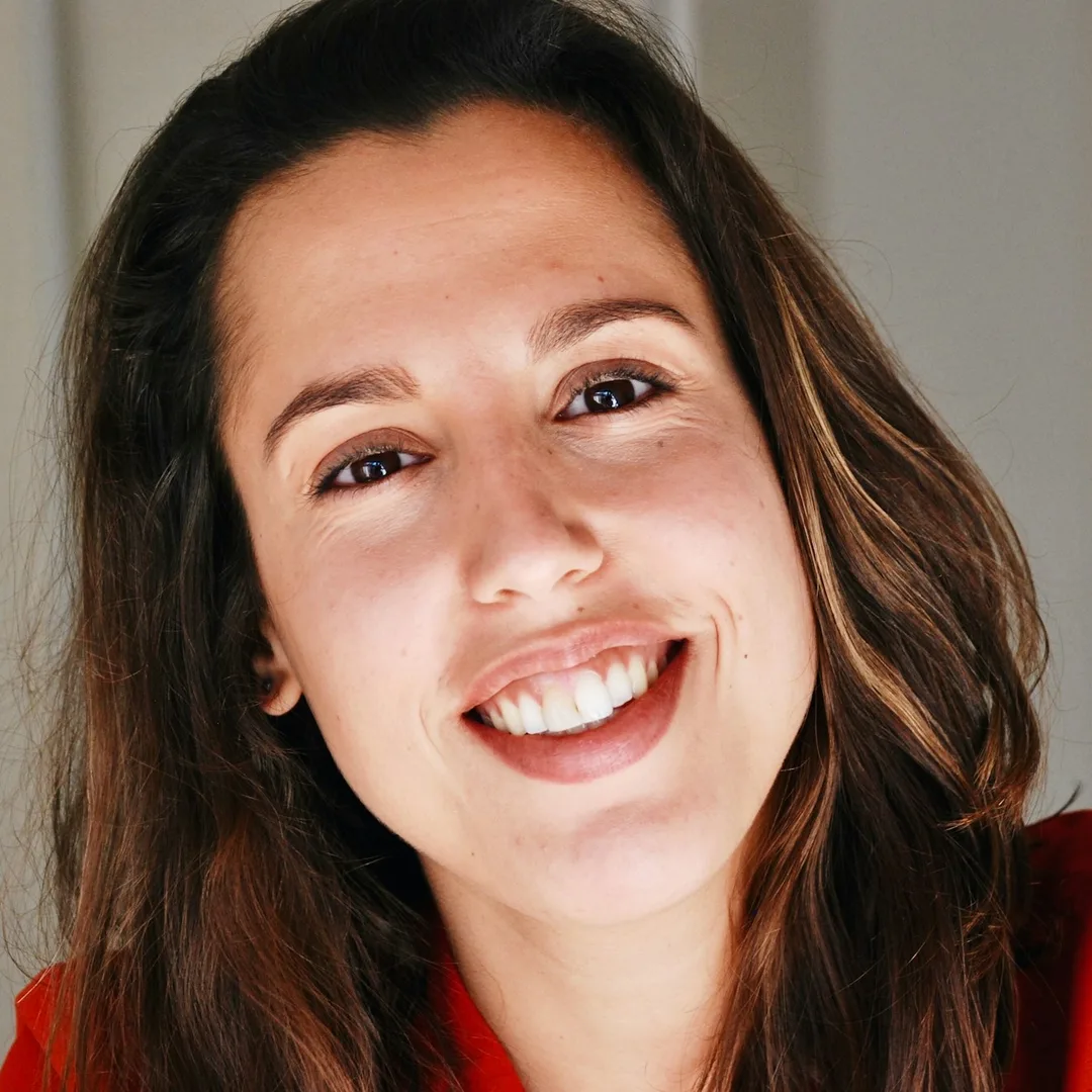 A woman smiling close up in warm daylight