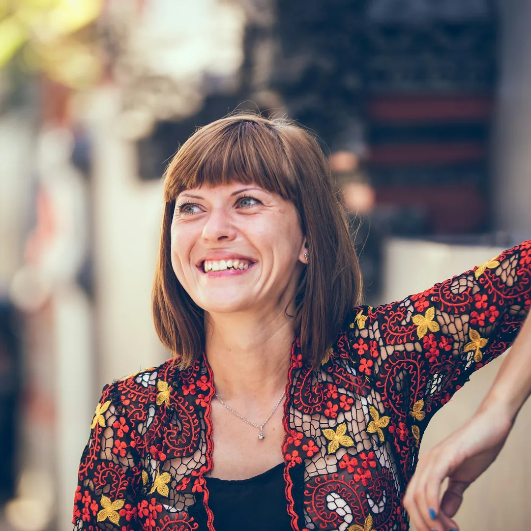 A woman laughing on a sunny street